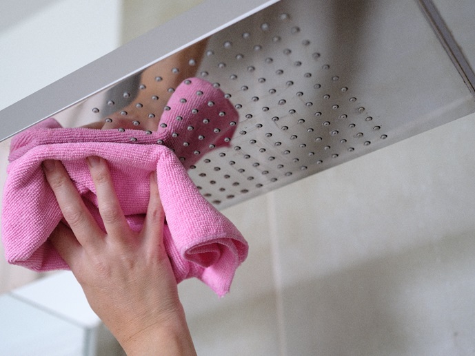 cleaning shower head with cloth and vinegar solution